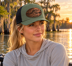 Blonde female model with single ponytail wearing Loden and black bass patch hat; digital mockup