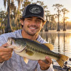 Male model wearing Flat River black and silver bass patch Richardson hat while holding a largemouth bass