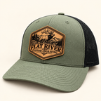 Flat River Bull Elk loden and black hat with engraved patch on ivory studio background