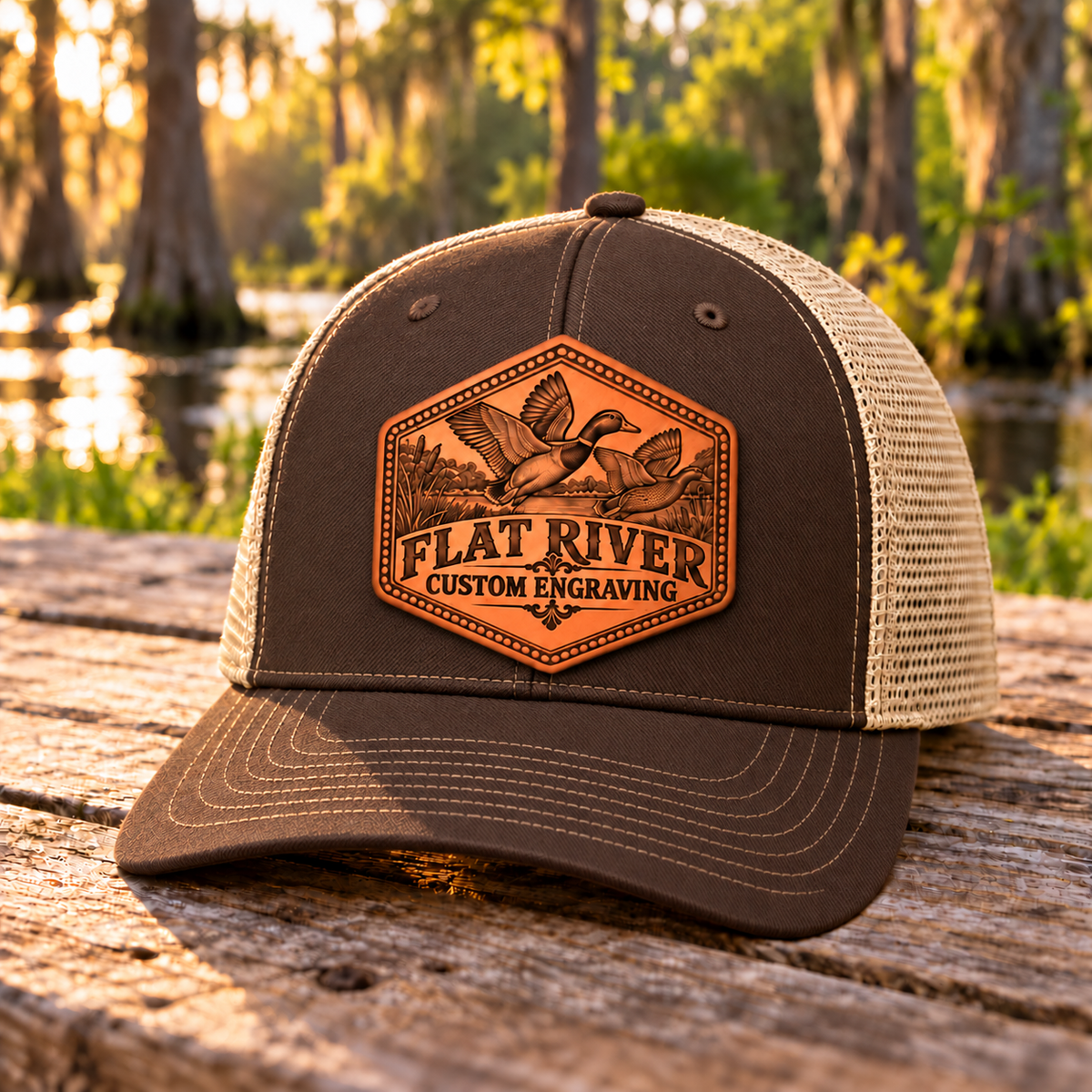 Flat River Mallard Richardson 112 Brown/Khaki hat with unchanged leatherette patch centered on the front seam, beside a Louisiana wetland